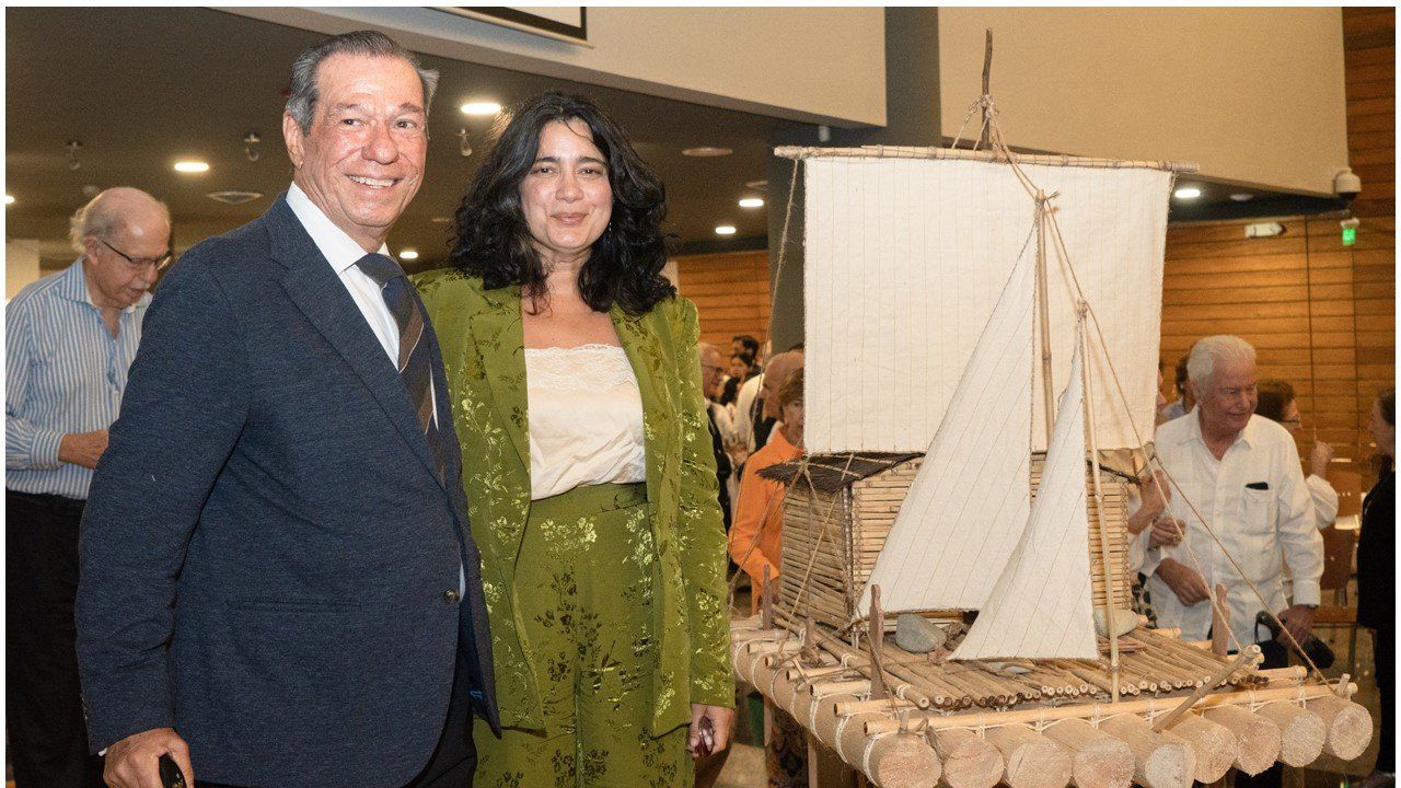 El autor posa con una asistente junto a la maqueta de la balsa durante la presentación en Guayaquil