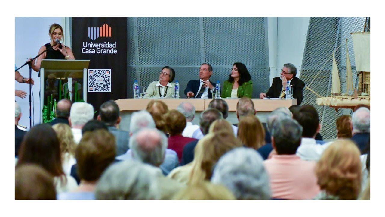 Mesa de presentación con cuatro panelistas ante el público, con el logo de la Universidad Casa Grande