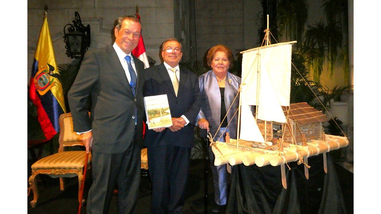 El autor con dos invitados entre las banderas de Ecuador y Perú y la maqueta de la balsa
