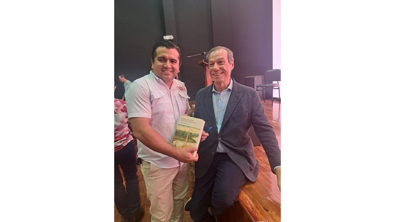 El autor posa con un lector que sostiene su ejemplar en Manta
