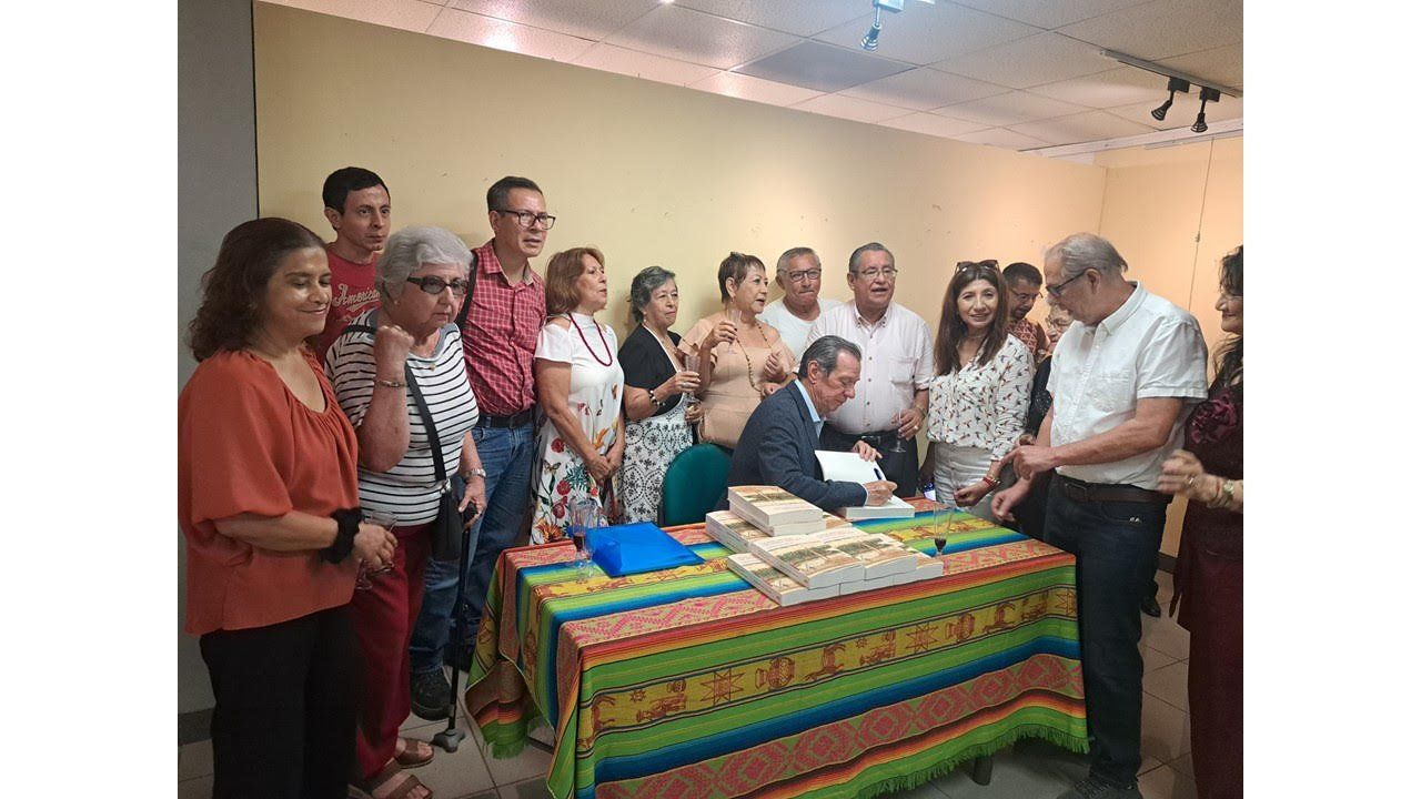 Fila de lectores alrededor de la mesa de firmas con ejemplares del libro en Portoviejo